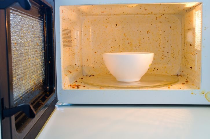 Pote com refei&ccedil;&atilde;o em micro-ondas com interior sujo