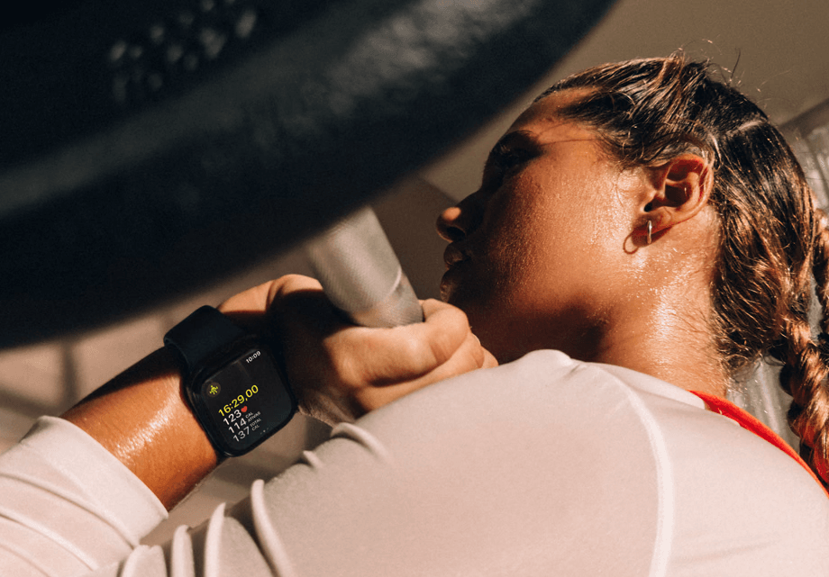 Mulher com o Apple Watch no pulso enquanto treina. Ele mede as calorias, passos, batimentos cardíacos e muito mais.